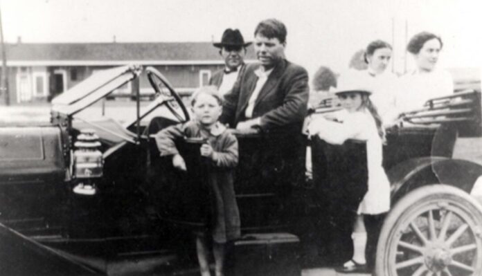 The discovered child beside a car with unidentified people